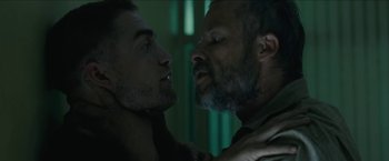 Movie still from “The Rover” (2014), directed by David Michôd – Two men face each other in a dark room; Close Up shot, Over the shoulder angle