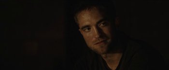 Movie still from “The Rover” (2014), directed by David Michôd – A person in a dark room; Close Up shot, Over the shoulder angle