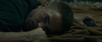 Movie still from “The Rover” (2014), directed by David Michôd – A person laying on the ground; Close Up shot, Overhead angle