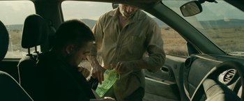 Movie still from “The Rover” (2014), directed by David Michôd – An older man and a young man in the back of a car; Medium shot, Over the shoulder angle