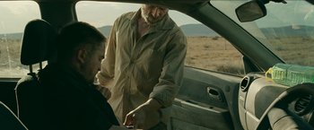 Movie still from “The Rover” (2014), directed by David Michôd – An older man and a young boy standing next to an open car door; Medium shot, Over the shoulder angle