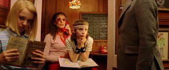 Movie still from “The Royal Tenenbaums” (2001), directed by Wes Anderson – A woman sitting next to a boy in front of a chalkboard; Medium shot, Over the shoulder angle