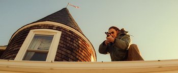 Movie still from “The Royal Tenenbaums” (2001), directed by Wes Anderson – A man is taking a picture of the sky with a camera; Medium shot, Low angle