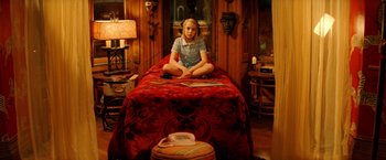 Movie still from “The Royal Tenenbaums” (2001), directed by Wes Anderson – A young girl sitting on a bed in a bedroom; Wide shot, High angle