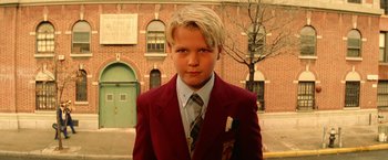 Movie still from “The Royal Tenenbaums” (2001), directed by Wes Anderson – A boy in a red jacket and a striped tie; Close Up shot, Low angle