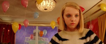 Movie still from “The Royal Tenenbaums” (2001), directed by Wes Anderson – A young girl in a room with balloons in the background; Close Up shot, High angle
