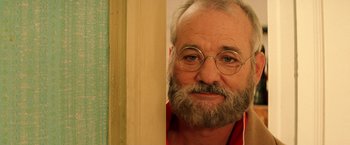 Movie still from “The Royal Tenenbaums” (2001), directed by Wes Anderson – An older man with a beard and glasses looking to his left; Close Up shot, Over the shoulder angle