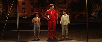 Movie still from “The Royal Tenenbaums” (2001), directed by Wes Anderson – Three young men standing on the side of the road; Wide shot, High angle