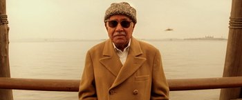Movie still from “The Royal Tenenbaums” (2001), directed by Wes Anderson – An older man wearing a coat and a hat; Close Up shot, Low angle