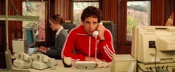 Movie still from “The Royal Tenenbaums” (2001), directed by Wes Anderson – A man sitting at a table talking on the phone; Medium shot, Over the shoulder angle