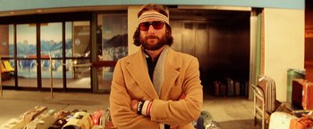 Movie still from “The Royal Tenenbaums” (2001), directed by Wes Anderson – A man with a beard wearing sunglasses and a jacket; Close Up shot, Low angle