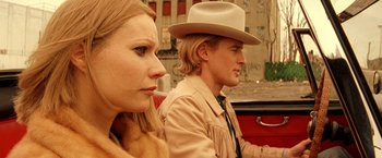 Movie still from “The Royal Tenenbaums” (2001), directed by Wes Anderson – A man and a woman sitting on a red car; Close Up shot, Low angle