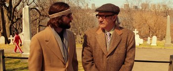 Movie still from “The Royal Tenenbaums” (2001), directed by Wes Anderson – A man and a man wearing a hat and glasses; Medium shot, Over the shoulder angle