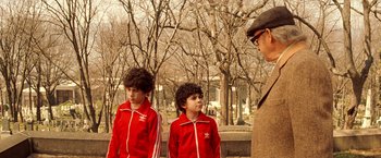 Movie still from “The Royal Tenenbaums” (2001), directed by Wes Anderson – Two young boys in red jackets standing next to each other; Medium shot, Over the shoulder angle