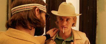 Movie still from “The Royal Tenenbaums” (2001), directed by Wes Anderson – A man putting a hat on a young man's face; Close Up shot, Over the shoulder angle