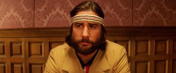 Movie still from “The Royal Tenenbaums” (2001), directed by Wes Anderson – A man with long hair and a beard wearing a headband; Close Up shot, Low angle