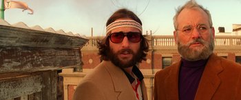Movie still from “The Royal Tenenbaums” (2001), directed by Wes Anderson – A man with a beard wearing sunglasses and a headband; Close Up shot, Low angle
