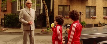 Movie still from “The Royal Tenenbaums” (2001), directed by Wes Anderson – Two young boys eating a banana in front of an older woman; Medium shot, Over the shoulder angle