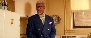 Movie still from “The Royal Tenenbaums” (2001), directed by Wes Anderson – An older man wearing a suit and bow tie; Close Up shot, Low angle