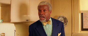 Movie still from “The Royal Tenenbaums” (2001), directed by Wes Anderson – An older man in a green and white checkered shirt; Close Up shot, Low angle