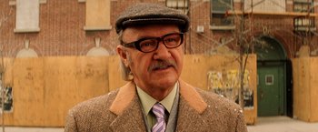 Movie still from “The Royal Tenenbaums” (2001), directed by Wes Anderson – An older man wearing glasses and a hat; Close Up shot, Low angle