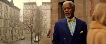 Movie still from “The Royal Tenenbaums” (2001), directed by Wes Anderson – An older man wearing a suit and a bow tie; Close Up shot, Low angle