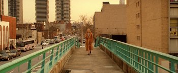 Movie still from “The Royal Tenenbaums” (2001), directed by Wes Anderson – A woman is walking across a bridge in the city; Extreme Wide shot, High angle