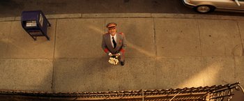 Movie still from “The Royal Tenenbaums” (2001), directed by Wes Anderson – An aerial view of a man in a uniform holding flowers; Extreme Wide shot, Overhead angle