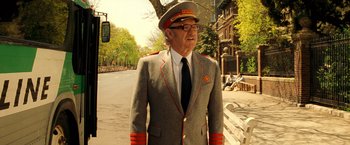Movie still from “The Royal Tenenbaums” (2001), directed by Wes Anderson – An older man in a military uniform walking down the street; Medium shot, Low angle