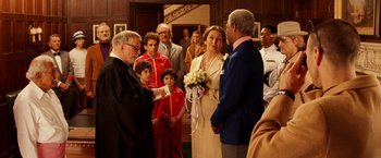 Movie still from “The Royal Tenenbaums” (2001), directed by Wes Anderson – A couple getting married in front of a crowd of onlookers; Medium shot, Over the shoulder angle