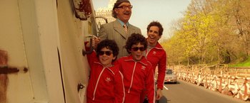 Movie still from “The Royal Tenenbaums” (2001), directed by Wes Anderson – A man and two young boys wearing red jackets; Medium shot, High angle