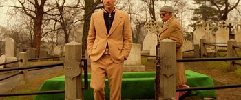 Movie still from “The Royal Tenenbaums” (2001), directed by Wes Anderson – A man in a suit standing in front of a grave; Medium shot, Low angle