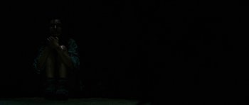 A person standing in the dark with a black background