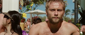 Movie still from “The Ruins” (2008), directed by Carter Smith – A man with no shirt in front of a group of people; Close Up shot, Low angle
