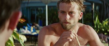 Movie still from “The Ruins” (2008), directed by Carter Smith – A man with a beard is holding a straw; Close Up shot, Low angle