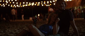 Movie still from “The Ruins” (2008), directed by Carter Smith – A woman holding a beer while sitting next to a man; Medium shot, Over the shoulder angle