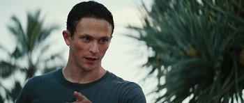 Movie still from “The Ruins” (2008), directed by Carter Smith – A person with a palm tree in the background; Close Up shot, Over the shoulder angle