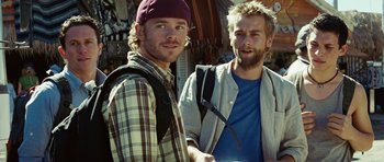 Movie still from “The Ruins” (2008), directed by Carter Smith – Two men standing next to each other on a sunny day; Close Up shot, Over the shoulder angle