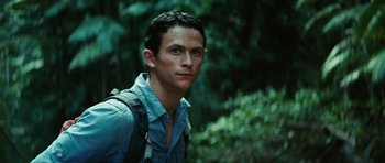 Movie still from “The Ruins” (2008), directed by Carter Smith – A man in a blue shirt and backpack in the woods; Close Up shot, Low angle