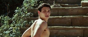 A shirtless man standing in front of some steps