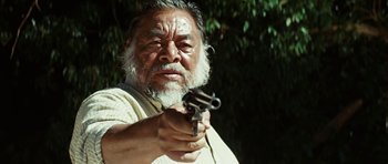 Movie still from “The Ruins” (2008), directed by Carter Smith – An older man holding a gun in his hand; Close Up shot, Low angle