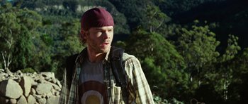 Movie still from “The Ruins” (2008), directed by Carter Smith – A man with a hat and a backpack on; Medium shot, Over the shoulder angle