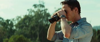 Movie still from “The Ruins” (2008), directed by Carter Smith – A man looking through a pair of binoculars; Close Up shot, Over the shoulder angle