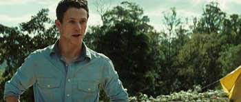 Movie still from “The Ruins” (2008), directed by Carter Smith – A man in a blue shirt is standing in a field; Close Up shot, Over the shoulder angle