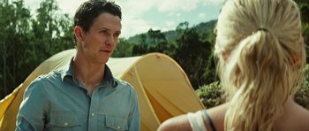 Movie still from “The Ruins” (2008), directed by Carter Smith – A man and a woman standing in front of a yellow tent; Close Up shot, Over the shoulder angle