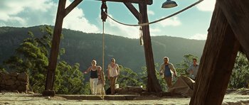 Movie still from “The Ruins” (2008), directed by Carter Smith – A group of people standing under a wooden structure; Extreme Wide shot, Low angle
