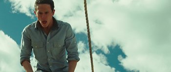 Movie still from “The Ruins” (2008), directed by Carter Smith – A man standing on top of a rope swing; Medium shot, Low angle