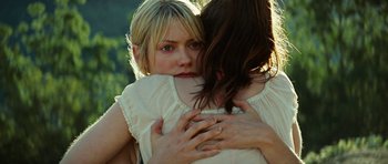 Movie still from “The Ruins” (2008), directed by Carter Smith – Two women hugging each other in the sunlight; Close Up shot, Over the shoulder angle