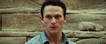 Movie still from “The Ruins” (2008), directed by Carter Smith – A person wearing a blue shirt; Close Up shot, High angle