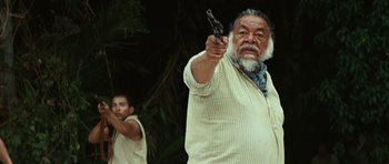 Movie still from “The Ruins” (2008), directed by Carter Smith – An older man holding a gun in front of a younger man; Medium shot, Low angle